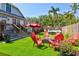 Backyard featuring artificial turf, a fire pit with Adirondack chairs, and a swim spa for relaxation and enjoyment at 1523 1St W Ave, Bradenton, FL 34205
