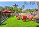 Backyard featuring artificial turf, a swim spa, and a fire pit surrounded by Adirondack chairs, perfect for outdoor enjoyment at 1523 1St W Ave, Bradenton, FL 34205