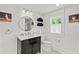 Stylish bathroom with black vanity, round mirror, and tiled floor at 1523 1St W Ave, Bradenton, FL 34205