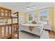 Spacious bedroom featuring a bunk bed, queen bed, fan, and sun-filled windows at 1523 1St W Ave, Bradenton, FL 34205