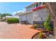 Home exterior featuring a brick paved area, AC units, and a charming garden bed, offering a cozy setting at 1523 1St W Ave, Bradenton, FL 34205