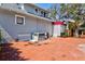 Exterior view showcasing a brick paved area, AC units, and a charming garden bed, perfect for relaxing at 1523 1St W Ave, Bradenton, FL 34205