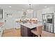 Charming kitchen boasts white cabinets, an island with marble countertop, and stainless steel appliances at 1523 1St W Ave, Bradenton, FL 34205