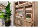 Rustic display cabinet featuring illuminated shelves stocked with towels, lotions, and decorative items, plus a potted plant at 15813 San Lazzaro Ave, Bradenton, FL 34211