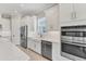 Modern kitchen with stainless steel appliances, a farmhouse sink, and white cabinets at 15813 San Lazzaro Ave, Bradenton, FL 34211
