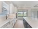 Bright kitchen with a large island, white quartz countertops, and a farmhouse sink with a view of the backyard at 15813 San Lazzaro Ave, Bradenton, FL 34211