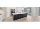 Modern kitchen features white cabinets, a large center island with seating, and stainless steel appliances at 15813 San Lazzaro Ave, Bradenton, FL 34211