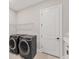 This laundry room features modern appliances, storage racks and a white door at 15813 San Lazzaro Ave, Bradenton, FL 34211