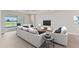 Cozy living room showcasing comfortable seating and large windows offering a view of the lush backyard at 15813 San Lazzaro Ave, Bradenton, FL 34211