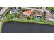 Aerial view of the home and neighborhood featuring a lake and backyard pools surrounded by mature landscaping at 1677 Fleetwood Dr, Sarasota, FL 34232