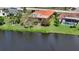 Aerial shot of a home with an orange tile roof and screened in pool in the backyard next to a lake at 1677 Fleetwood Dr, Sarasota, FL 34232