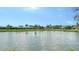 Expansive lake view surrounded by lush greenery and homes, complete with a charming fountain in the water at 1677 Fleetwood Dr, Sarasota, FL 34232