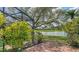 Screened patio with views of the lake, complemented by surrounding landscaping and a fountain feature in the water at 1677 Fleetwood Dr, Sarasota, FL 34232