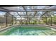 Screened pool overlooking beautiful lake scenery with a pool that has a decorative tile trim at 1677 Fleetwood Dr, Sarasota, FL 34232