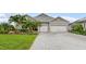 Charming single-story home featuring a two-car garage, well-manicured lawn and tropical landscaping at 17204 Bullhorn Cir, Punta Gorda, FL 33982