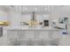 Bright, modern kitchen with white cabinets, quartz countertops, and a spacious island with bar seating at 17204 Bullhorn Cir, Punta Gorda, FL 33982