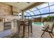 Enjoy the outdoors with an outdoor kitchen, dining table, and chairs under a screened in lanai by the pool at 17204 Bullhorn Cir, Punta Gorda, FL 33982