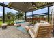 Relax in this beautifully decorated lanai with outdoor seating, a fire pit, and lush landscaping views at 17204 Bullhorn Cir, Punta Gorda, FL 33982