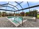 Enjoy this geometric-shaped swimming pool with a hot tub, framed by lush landscaping, all within a screened lanai at 17204 Bullhorn Cir, Punta Gorda, FL 33982