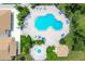 Aerial view of the pool with lounge chairs, the spa, and the manicured landscaping of the community at 175 Inlets Blvd # 175, Nokomis, FL 34275
