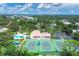 Expansive aerial view showcases the community's pool, tennis courts, clubhouse, and mature trees at 175 Inlets Blvd # 175, Nokomis, FL 34275