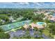 Aerial view showcasing community amenities like tennis courts and a pool amid lush greenery and homes at 175 Inlets Blvd # 175, Nokomis, FL 34275