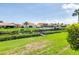 Green backyard with a waterway, boat dock, and view of neighboring homes and lush landscaping at 175 Inlets Blvd # 175, Nokomis, FL 34275