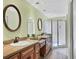 Well-lit bathroom features dual sinks, wood cabinets, and a glass enclosed shower at 175 Inlets Blvd # 175, Nokomis, FL 34275
