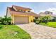 Charming exterior view of home with a two-car garage, tile roof, and nicely paved driveway at 175 Inlets Blvd # 175, Nokomis, FL 34275