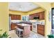 Well-equipped kitchen with wooden cabinets, granite countertops, a center island, and updated appliances at 175 Inlets Blvd # 175, Nokomis, FL 34275