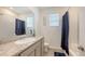 Bathroom featuring granite counters, neutral cabinets, and a shower-tub combo at 17817 Pastureland Ave, Lakewood Ranch, FL 34211