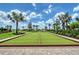 Bocce ball court with lush landscaping surrounded by palm trees and a bright blue sky at 17817 Pastureland Ave, Lakewood Ranch, FL 34211