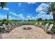 Outdoor fire pit with seating, surrounded by landscaping and a serene lake view at 17817 Pastureland Ave, Lakewood Ranch, FL 34211