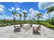 Cozy outdoor fire pit with Adirondack chairs and lush landscaping with a bright blue sky at 17817 Pastureland Ave, Lakewood Ranch, FL 34211