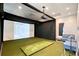 Golf simulator room with screen, projector, and seating for indoor practice at 17817 Pastureland Ave, Lakewood Ranch, FL 34211