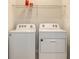 Laundry room showing white washer and dryer with a wire rack above at 17817 Pastureland Ave, Lakewood Ranch, FL 34211