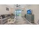 Bright living room featuring modern decor, a ceiling fan, and sliding glass doors to the outdoor area at 17817 Pastureland Ave, Lakewood Ranch, FL 34211
