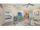 Open living room with a comfortable couch, stylish rug, view of the kitchen and connected bedroom at 17817 Pastureland Ave, Lakewood Ranch, FL 34211