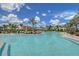 Community pool with lounge chairs, umbrellas, and cabanas, surrounded by palm trees at 17817 Pastureland Ave, Lakewood Ranch, FL 34211