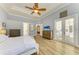 Well-lit bedroom boasts a tray ceiling, light walls, wood floors, and French doors to the outdoor living space at 20207 71St E Ave, Bradenton, FL 34211