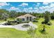 Expansive exterior view of home with tile roof, circle driveway, mature trees, and manicured landscaping at 20207 71St E Ave, Bradenton, FL 34211