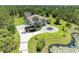 An aerial view of an elegant home with lush landscaping, a circular drive, and a pond at 20207 71St E Ave, Bradenton, FL 34211