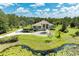A beautiful exterior elevation features tropical landscaping, a circular driveway, and a pond in the front yard at 20207 71St E Ave, Bradenton, FL 34211