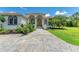 Charming home with tile roof, arched entry, manicured landscaping, and a stone driveway at 20207 71St E Ave, Bradenton, FL 34211