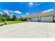 This home's back elevation features a three-car garage with a large driveway for parking and a manicured backyard at 20207 71St E Ave, Bradenton, FL 34211