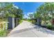The estate's entrance is framed by an iron gate leading to a long driveway through mature trees at 20207 71St E Ave, Bradenton, FL 34211