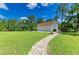 A large lawn area with a pathway that leads to a three car garage, providing ample parking and storage at 20207 71St E Ave, Bradenton, FL 34211