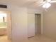 Bedroom with ceiling fan, closet with sliding doors and doorway view to bathroom with light green tile at 2155 Wood St # A26, Sarasota, FL 34237