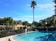 Community pool with palm trees, lounge chairs and exterior views at 2155 Wood St # A26, Sarasota, FL 34237