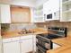 A well-lit kitchen features white cabinets, butcher block countertops, and stainless-steel appliances at 2155 Wood St # A26, Sarasota, FL 34237